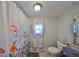 Bathroom with floral shower curtain, toilet, and single vanity at 3207 Acacia St, Lutz, FL 33558