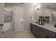 Contemporary bathroom featuring a double vanity with quartz countertops, framed mirrors, and glass-enclosed shower at 4206 Feldspar Ln, Spring Hill, FL 34609