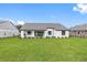 Back exterior of a single-story house with covered patio and lush lawn at 4555 Hickory Oak Dr, Brooksville, FL 34601