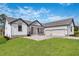 Modern two-story home with three car garage and manicured lawn at 6773 Summit View Dr, Brooksville, FL 34601