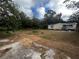 Large backyard with overgrown grass and a concrete slab at 9131 Kosimo St, New Port Richey, FL 34654