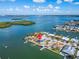 Aerial view of a waterfront property with surrounding houses and lush greenery at 12520 4Th E St, Treasure Island, FL 33706