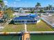 An aerial view of a waterfront home with solar panels and a private dock at 12520 4Th E St, Treasure Island, FL 33706