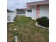 Side yard with grass and a white fence, overlooking the water at 12520 4Th E St, Treasure Island, FL 33706