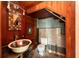 Small bathroom with mosaic mirror, vintage sink, and wood-paneled walls at 1311 E Park Cir, Tampa, FL 33604