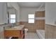 This bathroom has a granite countertop with wood cabinets and a tiled shower and bathtub combo at 1312 E Louise Ave, Tampa, FL 33603