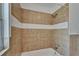 Bathroom with tan tile, a white stripe, and chrome shower head at 1312 E Louise Ave, Tampa, FL 33603