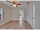 This bedroom features light hardwood floors, white trim, a ceiling fan with lighting, and a view to the exterior at 1312 E Louise Ave, Tampa, FL 33603