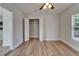 This bedroom features light hardwood floors, an open closet with white doors, and a ceiling fan with lighting at 1312 E Louise Ave, Tampa, FL 33603