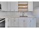 A kitchen with stainless steel appliances, white cabinets, quartz countertops, and subway tile backsplash at 1312 E Louise Ave, Tampa, FL 33603