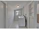 Bright laundry room featuring a white washer, dryer, and built-in shelving at 1312 E Louise Ave, Tampa, FL 33603