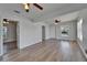 Bright and airy living room with wood floors, featuring multiple entryways and ceiling fans at 1312 E Louise Ave, Tampa, FL 33603