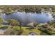 Waterfront property featuring a large lake, landscaped yard, and screened-in pool at 13811 Shady Shores Dr, Tampa, FL 33613