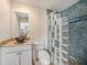 Bright bathroom featuring granite counters, bowl sink, glass block shower, and blue tiled walls at 13811 Shady Shores Dr, Tampa, FL 33613