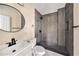 Modern bathroom featuring a sleek vanity, round mirror, and tiled walk-in shower at 13811 Shady Shores Dr, Tampa, FL 33613