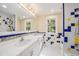 Colorful bathroom with double sinks, large mirror and shower at 13811 Shady Shores Dr, Tampa, FL 33613
