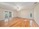 Bright living room featuring wood floors, neutral walls, and sliding glass doors to the outdoor pool area at 13811 Shady Shores Dr, Tampa, FL 33613