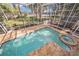 Aerial view of the pool and hot tub with screened enclosure and tropical greenery at 13811 Shady Shores Dr, Tampa, FL 33613