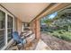 Covered porch with tile flooring, brick pillars, and views of the front yard at 13811 Shady Shores Dr, Tampa, FL 33613