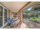 Inviting front porch with brick columns, tile flooring, and a relaxing chair at 13811 Shady Shores Dr, Tampa, FL 33613
