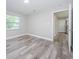 Bright bedroom with wood-look floors and access to hallway at 17504 Marsh Rd, Lutz, FL 33558