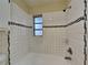 Clean bathroom with white tile, bathtub, and shower at 315 Lime Tree Rd, Tampa, FL 33619