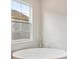 Bright bathroom featuring a modern freestanding soaking tub and fixtures, perfect for relaxation and comfort at 35298 Big Hawk Dr, Zephyrhills, FL 33541