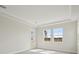 Bright bedroom with tray ceiling, large windows, and a glass door at 35298 Big Hawk Dr, Zephyrhills, FL 33541