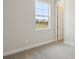 Bedroom with carpet flooring and an open doorway and window overlooking the landscape at 35298 Big Hawk Dr, Zephyrhills, FL 33541