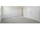 Bright bedroom featuring neutral carpet, white walls, a closet, and an open doorway at 35298 Big Hawk Dr, Zephyrhills, FL 33541