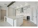 Modern kitchen featuring white cabinetry, stainless steel appliances, and a large island with a farmhouse sink at 35298 Big Hawk Dr, Zephyrhills, FL 33541
