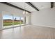 Open living space with porcelain floors, vaulted ceilings, wooden beams and sliding doors to the backyard at 35298 Big Hawk Dr, Zephyrhills, FL 33541