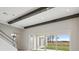 Spacious living room with high ceilings, wooden beams, and sliding glass doors leading to the outdoor space at 35298 Big Hawk Dr, Zephyrhills, FL 33541