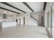 Bright open-concept living space with porcelain tile floors and high ceilings with wooden beams at 35298 Big Hawk Dr, Zephyrhills, FL 33541