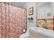 Cozy bathroom features patterned shower curtain, neutral vanity, and decorative shelving at 860 25Th N Ave, St Petersburg, FL 33704