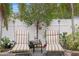 Relaxing patio area with two lounge chairs, a small table, and lush greenery at 860 25Th N Ave, St Petersburg, FL 33704