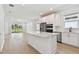 Open-concept kitchen with white cabinets, stainless appliances, large island, and adjacent living area at 9434 Shorebird Ct, Parrish, FL 34219