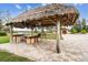 Outdoor kitchen with thatched roof and built-in grill at 10930 Earhart Dr, New Port Richey, FL 34654