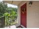 Inviting condo entry with red door and wreath, overlooking green landscape at 11701 Raintree Village Blvd # C, Temple Terrace, FL 33617