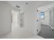 Hallway leading to a bathroom featuring gray floors, a glass shower and white walls at 126 4Th Ne Ave # 1302, St Petersburg, FL 33701