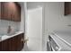 Functional laundry room with wooden cabinets, sink, and modern washer and dryer at 126 4Th Ne Ave # 1302, St Petersburg, FL 33701