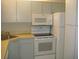 White kitchen cabinets, appliances, and laminate countertops at 3161 Lake Pine S Way # B1, Tarpon Springs, FL 34688