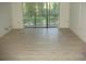 Living room with light gray vinyl plank flooring and sliding glass doors at 3161 Lake Pine S Way # B1, Tarpon Springs, FL 34688