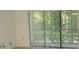 Bright living room with sliding glass doors leading to a private patio and lush greenery at 3161 Lake Pine S Way # B1, Tarpon Springs, FL 34688