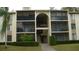 Two-story building with screened balconies and lush landscaping at 3161 Lake Pine S Way # B1, Tarpon Springs, FL 34688