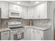 Bright kitchen features granite countertops and white cabinets at 8404 Millwood Dr, Hudson, FL 34667
