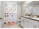 Bathroom featuring double sinks, white cabinets, and a shower with a patterned curtain at 9407 Channing Hill Dr, Ruskin, FL 33573