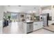 Open-concept kitchen featuring a central island, stainless steel appliances, and seamless flow into the living area at 9407 Channing Hill Dr, Ruskin, FL 33573