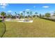 Community picnic area featuring picnic tables, a grassy lawn, tall palms, and a black metal fence at 9407 Channing Hill Dr, Ruskin, FL 33573