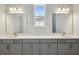 Bathroom with double sinks, quartz countertops, and stylish lighting fixtures at 17525 Glistening Ct, Venice, FL 34293